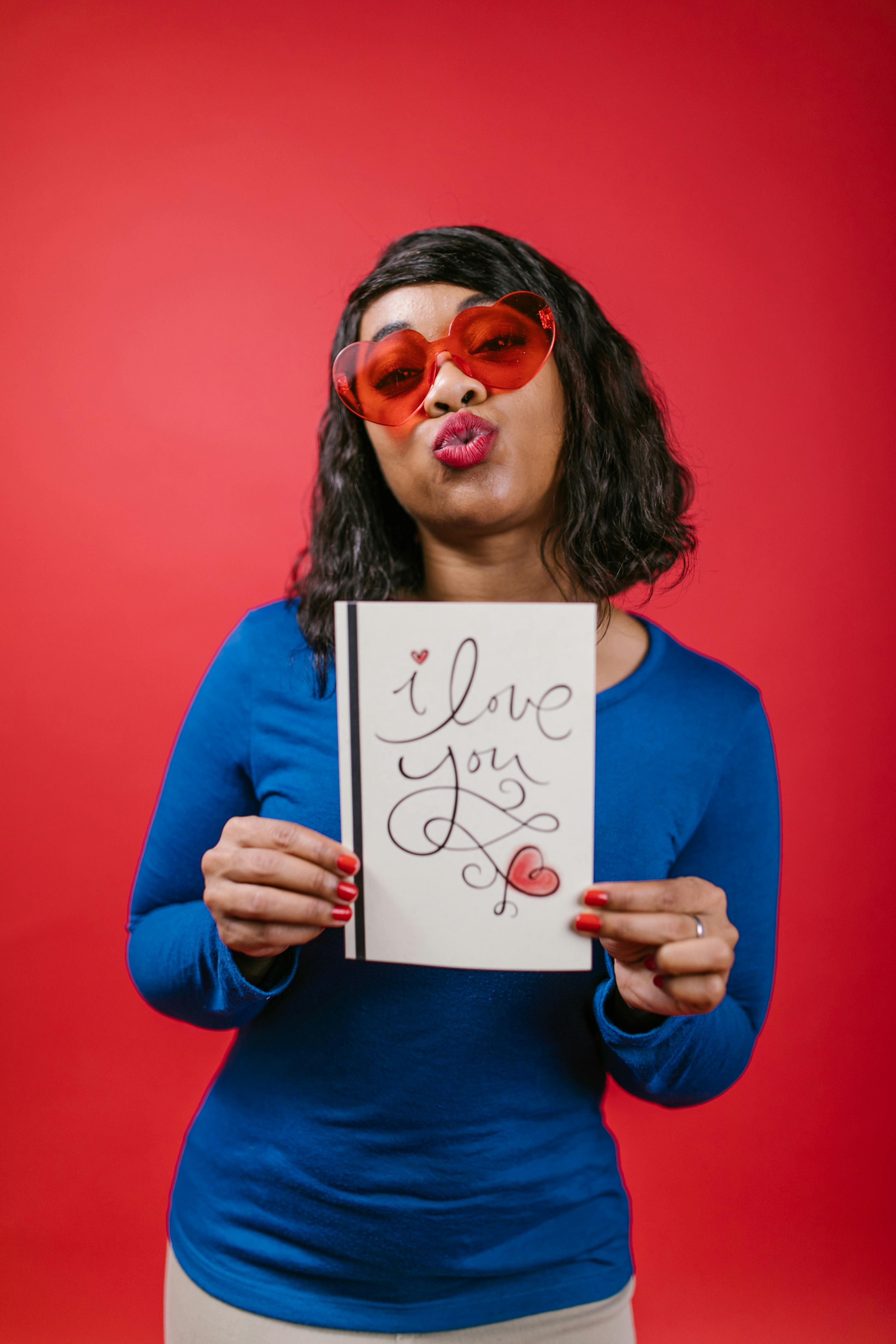 woman in blue long sleeve shirt holding valentine s day card