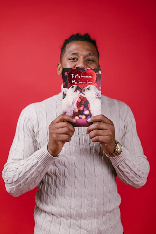 Man in White Sweater Holding a Valentine's Day Card