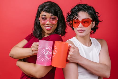 Free Two Women Holding Pink and Red Mugs Stock Photo