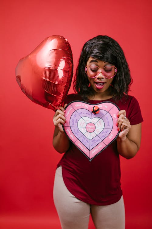 Woman in Red Crew Neck Shirt Holding Valentine's Day Gifts