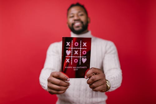 Man in White Long Sleeve Shirt Holding Valentine's Day Card