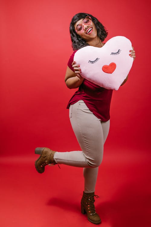 Woman Holding a Pink Heart Shaped Pillow