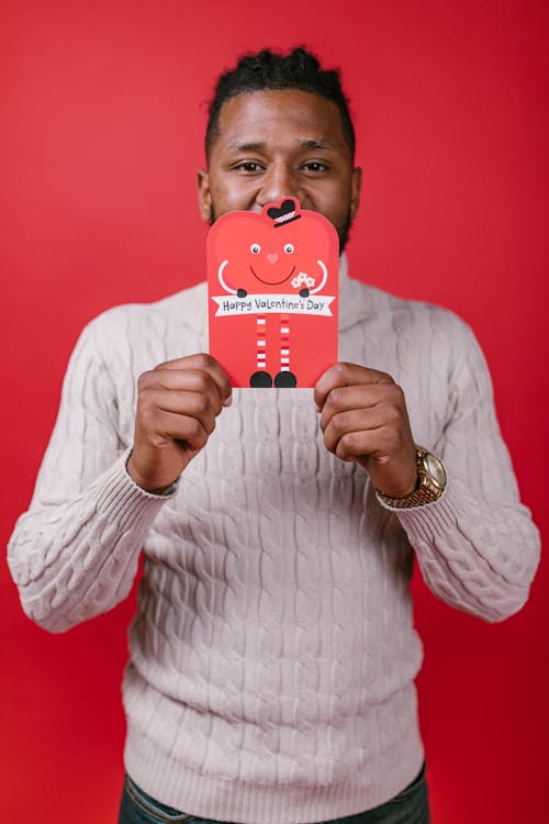 Man in White Long Sleeve Shirt Holding Valentine's Day Card