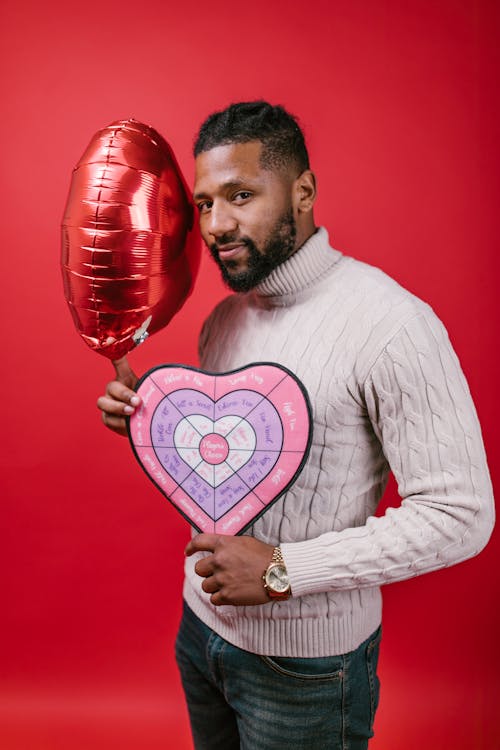 Free Man in White Long Sleeve Shirt Holding Valentine's Day Gifts Stock Photo