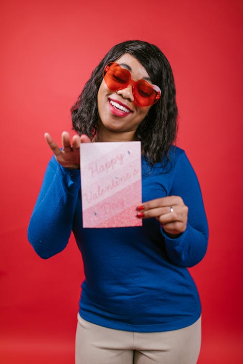 Free Woman in Blue Long Sleeve Shirt Holding Valentines Card Stock Photo