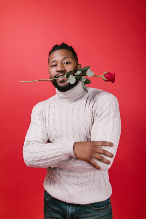 Man in White Turtleneck Sweater Holding Red Rose