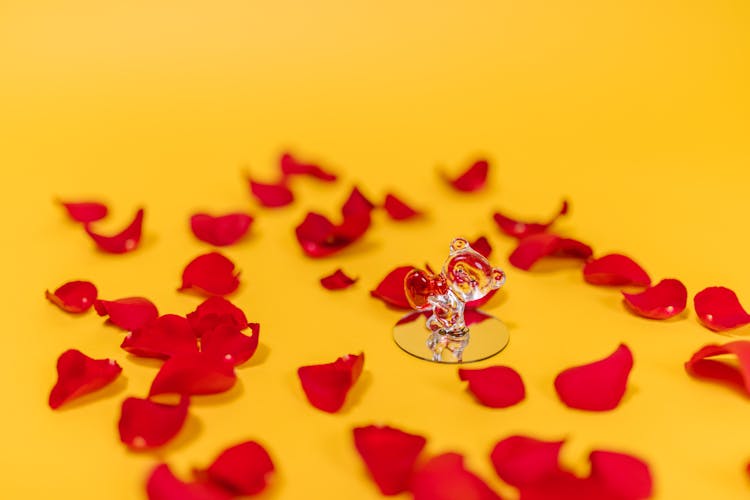 Miniature Toy And Red Flower Petals