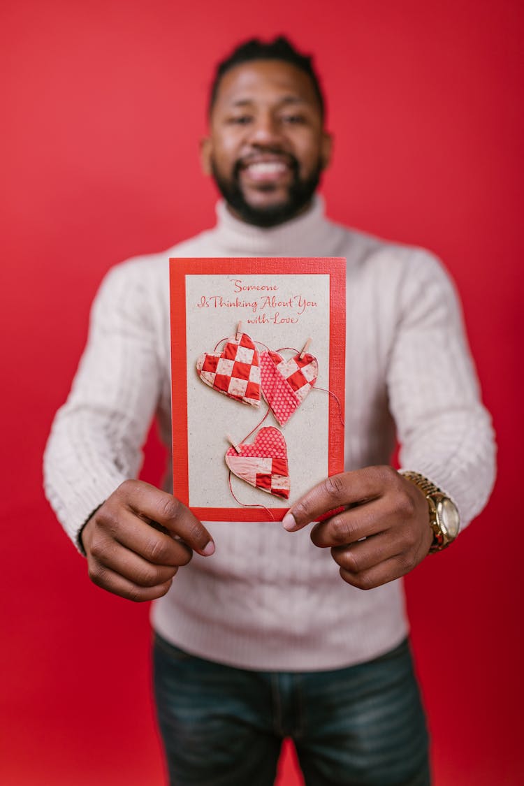 Man In White Long Sleeve Shirt Holding A Valentines Card