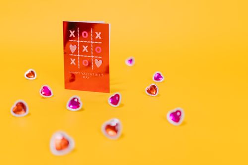 Free Red valentine card with heart decorations on a vibrant yellow background. Stock Photo