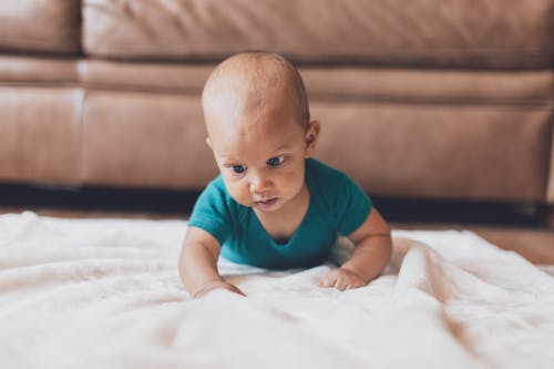 Shallow Focus of Cute Baby Crawling on Blanket