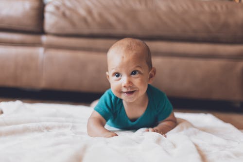 Shallow Focus of Cute Baby Crawling on Blanket