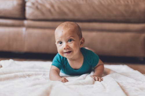 Shallow Focus of Cute Baby Crawling on Blanket