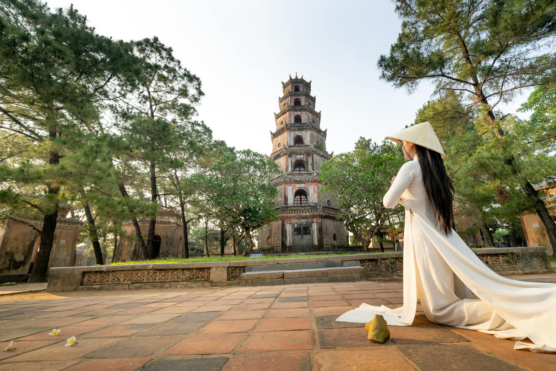 Anonymous woman praying near old temple in Vietnam