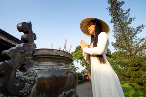 Asian woman praying near tripod