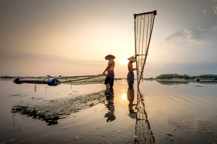 Asian Fishermen With Fishing Net In River