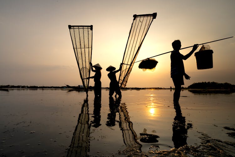 Faceless Fishermen In River With Fishing Net