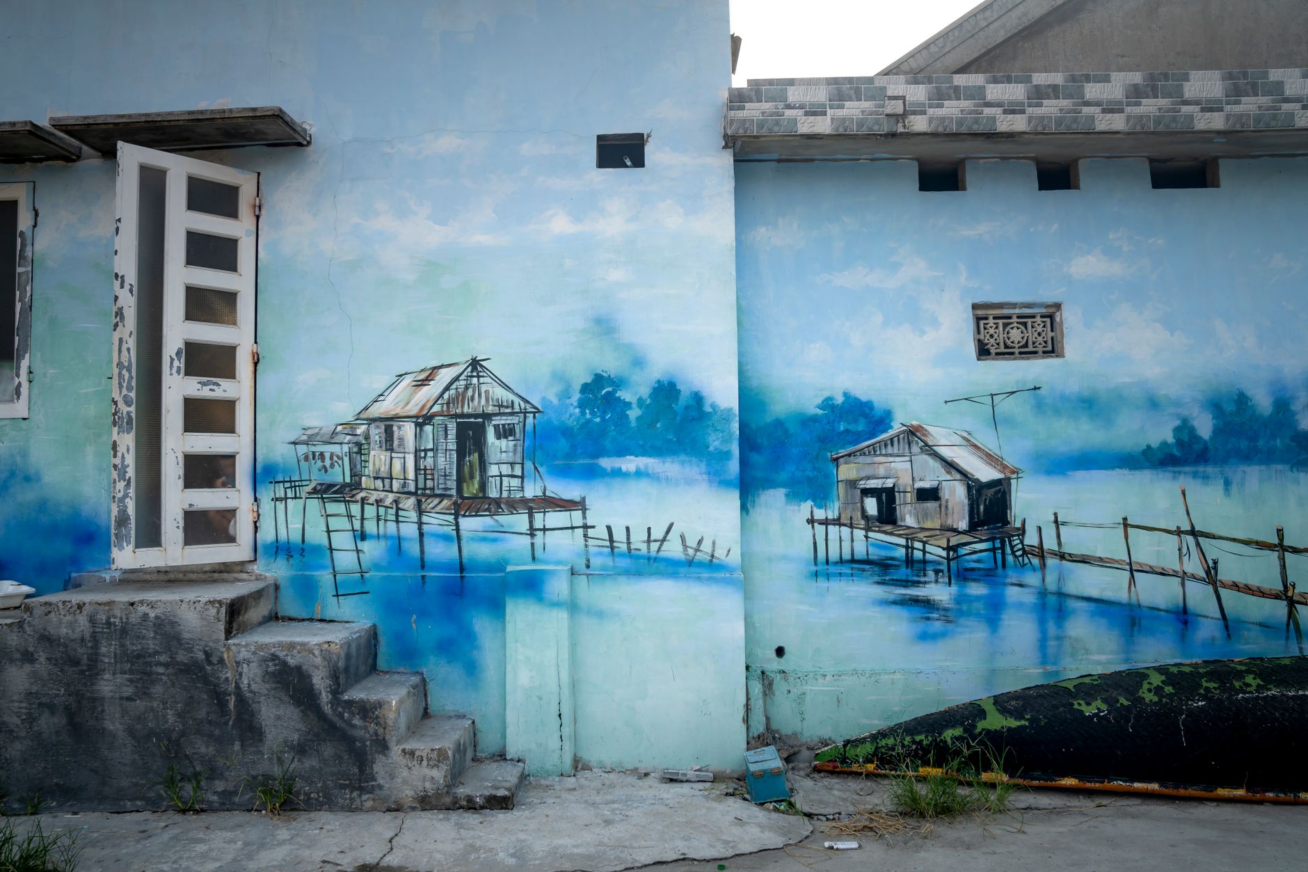 Front Door Color Ideas: Transform Your Entryway - Your Source for the Latest Housing Trends | Housing Market News| Exterior of building with aged staircase and shabby door and blue colored graffiti