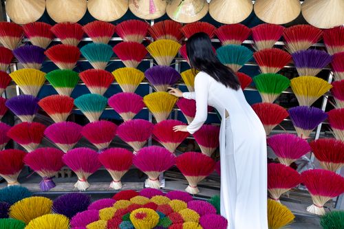 Free Back view of anonymous female buyer in white wear picking aromatic sticks in form of bouquets on shelves Stock Photo
