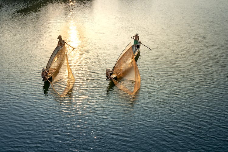 Anonymous Fishermen Catching Fish In Rippled Ocean In Evening