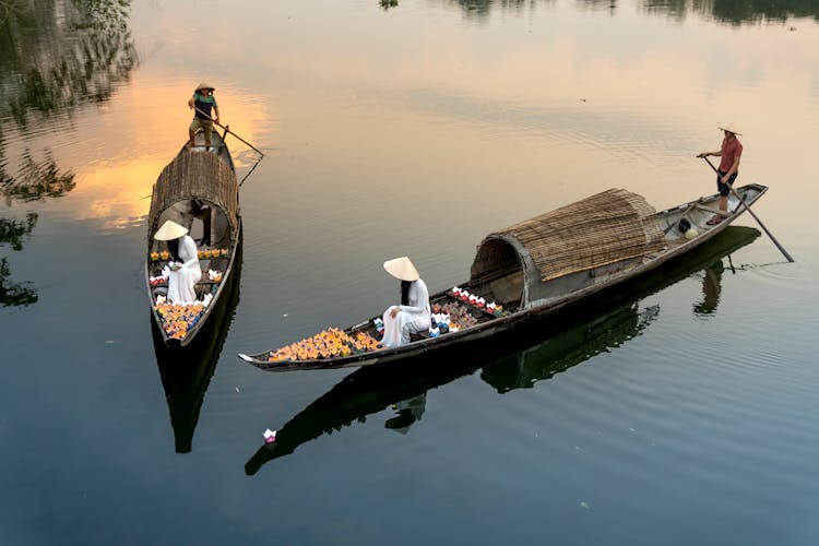 Anonymous Men And Women In Fishing Boats On River