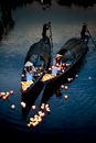Unrecognizable people in boats during oriental lantern festival at dusk