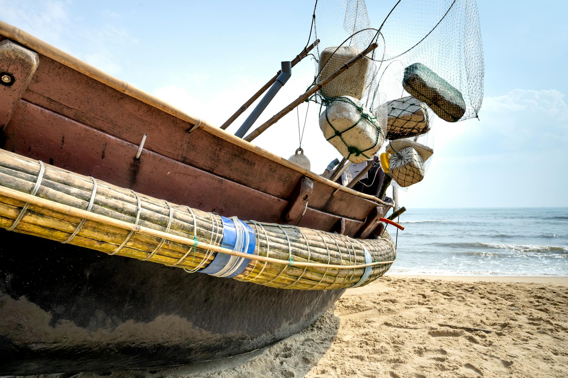 Fishing boat with equipment on ocean shore in sunlight
