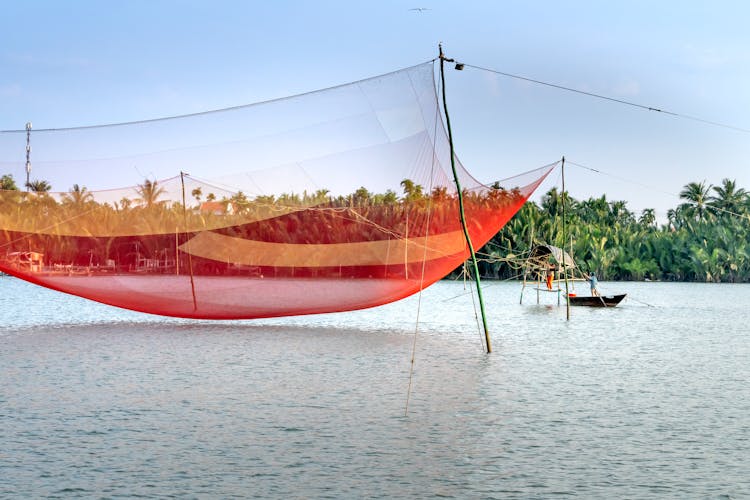 Boat Near Large Lift Fishing Net On River In Tropical Country