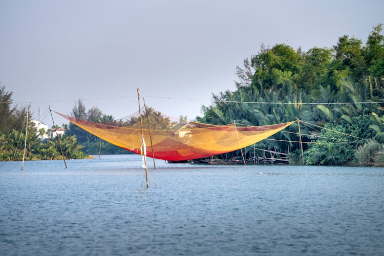 Traditional Lift Fishing Net Over River Near Tropical Forest In Vietnam