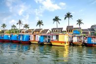Motorboats moored on river in tropical town on sunny day