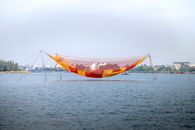 Large vivid net hanging on bamboo poles over rippling river in Hoi An during fishing