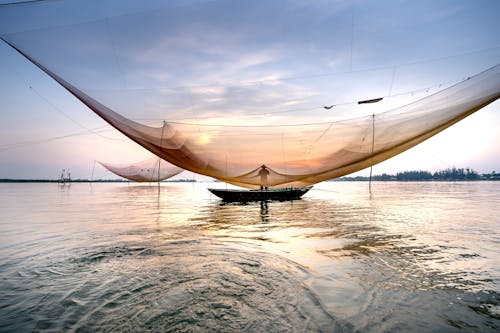 Unrecognizable man near fishing net on sea