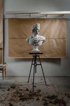 Elegant marble bust of a man displayed in an art studio with a rustic backdrop, perfect for artistic and educational purposes.