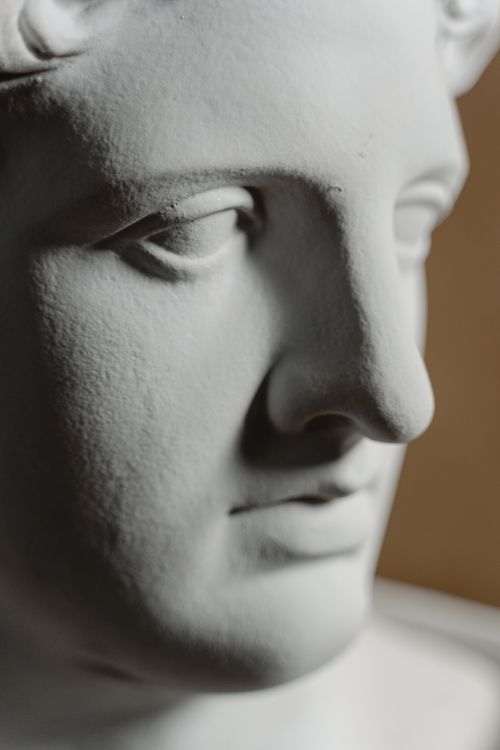 Free Detailed close-up of a white marble sculpture's face showcasing classical artistry. Stock Photo