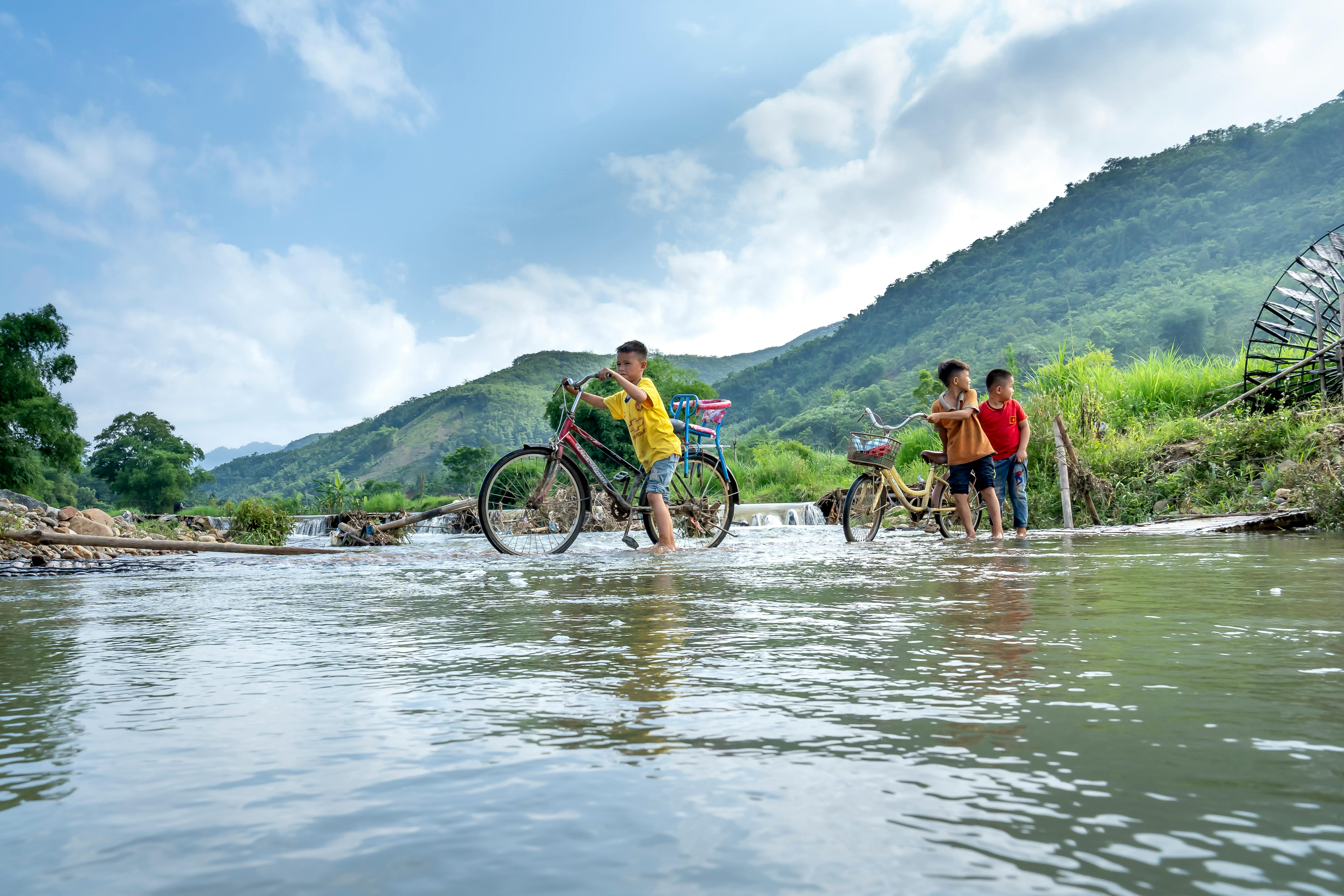 group of ethnic kids walking through river