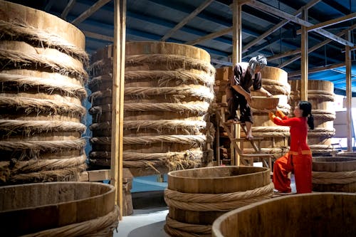 Colleagues working in warehouse with barrels