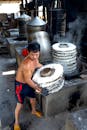 Man making noodle on caps in factory near machines