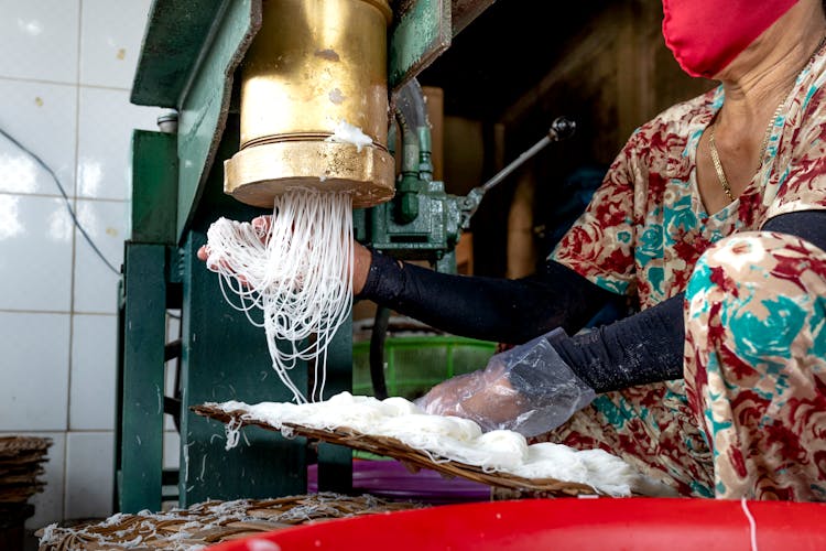 Unrecognizable Female In Mask On Manufacture Making Noodle On Machine