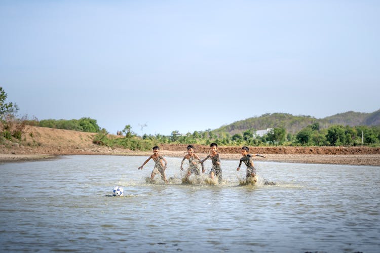 Ethnic Children Playing On River In Summer