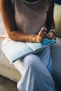 Close-Up Shot of a Woman Holding a Pen and a Book