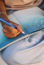 Person Holding a Blue Pen on Blue Paper