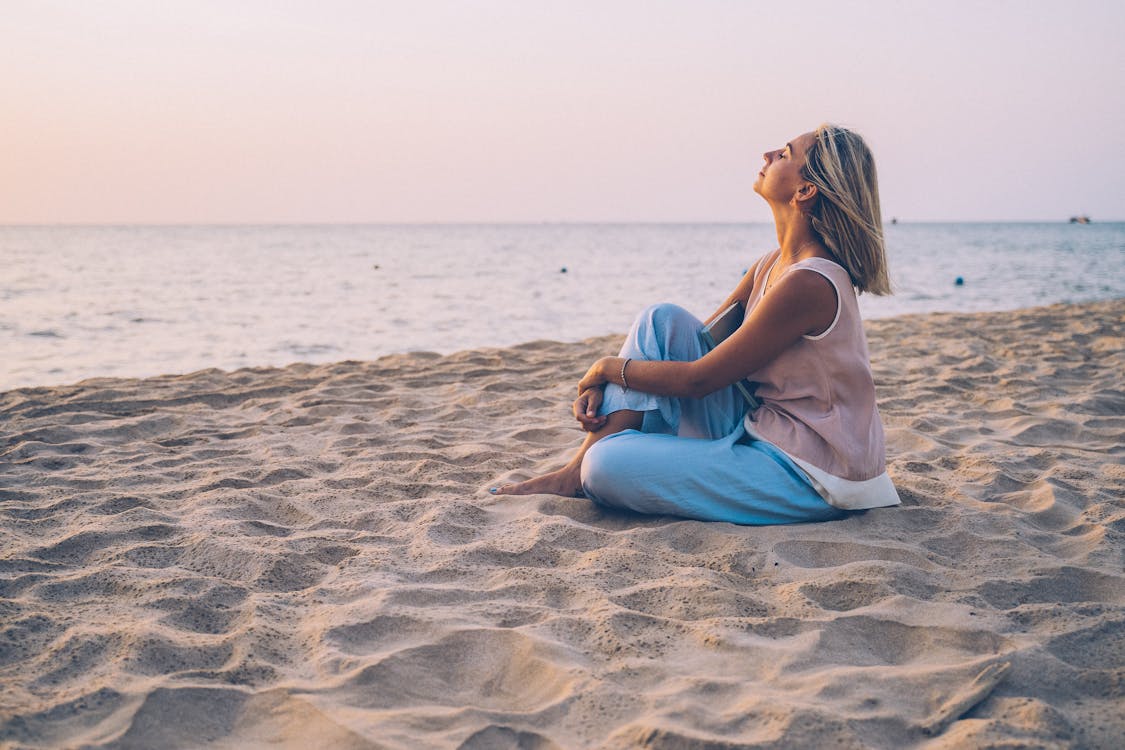 Free A Blonde Woman Relaxing on the Beach Stock Photo