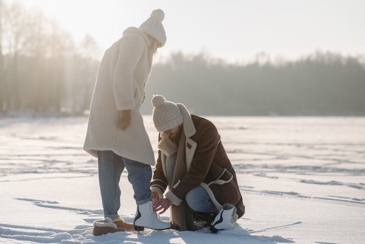 Man Tying The Person's Shoes