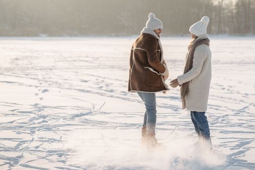 Free A couple enjoying ice skating together on a snowy day, showcasing winter fun and love. Stock Photo