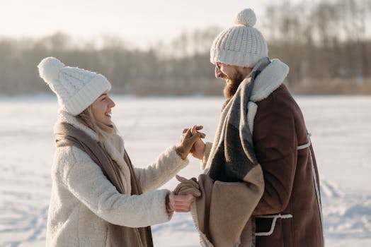Joyful couple holding hands in snowy winter scene outdoors.