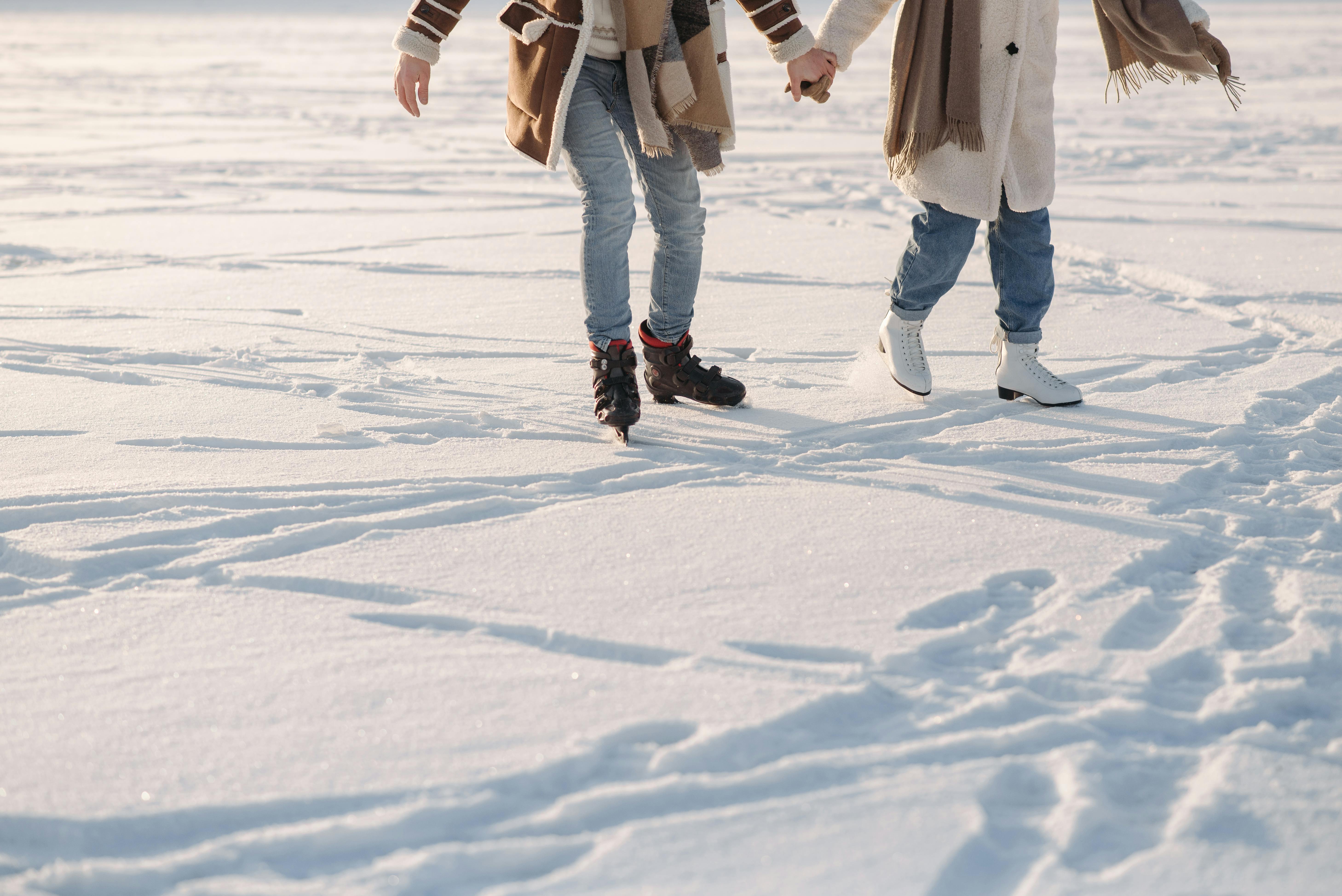 A Couple Holding Hands while Ice Skating · Free Stock Photo