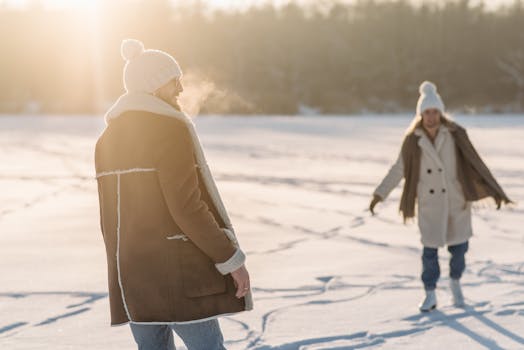 A man and woman enjoy a sunny winter day on a snowy landscape.