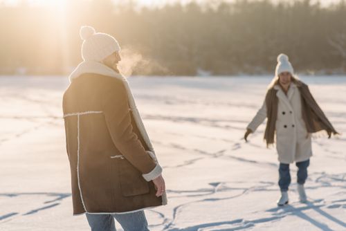 Free A man and woman enjoy a sunny winter day on a snowy landscape. Stock Photo