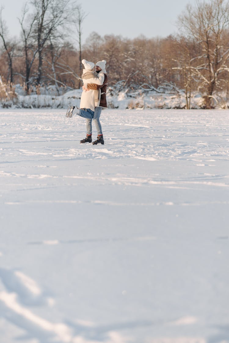 A Couple Ice Skating On Snow Covered Ground