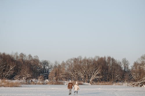 A Couple Ice Skating on Snow Covered Ground
