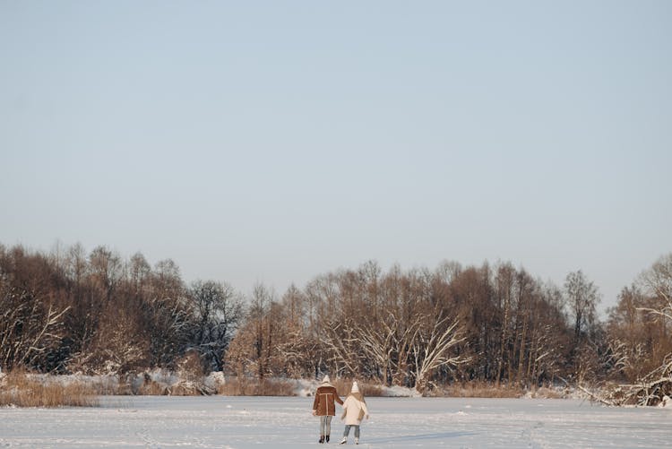 A Couple Ice Skating On Snow Covered Ground